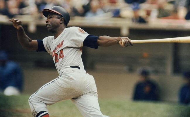 jugador de béisbol profesional Hank Aaron de los Bravos de Atlanta blandiendo un bate de béisbol en un estadio de béisbol