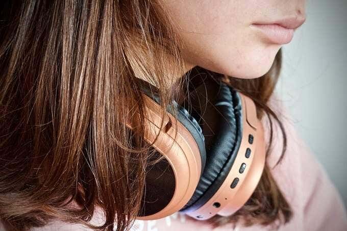 Alguien con auriculares colgados del cuello.
