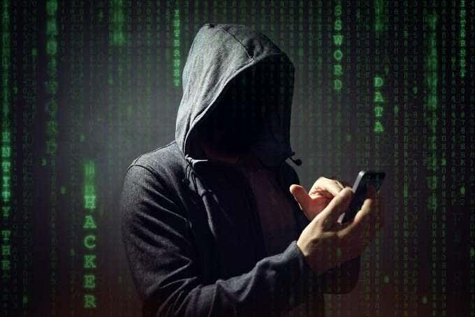 Un personaje con una sudadera con capucha escribiendo en un iPhone