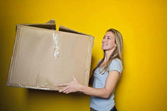 Una mujer sosteniendo una caja grande.