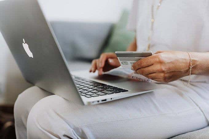 Alguien con una tarjeta de crédito y usando una computadora portátil