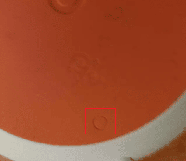 botón de restablecimiento de fábrica (círculo grabado) en el dispositivo Google Home Mini